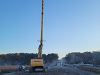 Machine supports wick drain held vertically during installation.